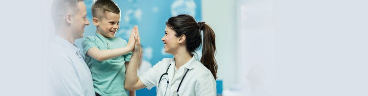 A young boy giving a female doctor a high five.